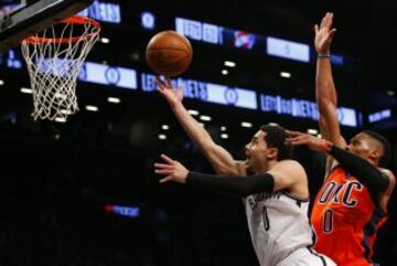 Jan 24, 2016; Brooklyn, NY, USA; Brooklyn Nets guard Shane Larkin (0) drives by Oklahoma City Thunder guard Russell Westbrook (0) for a layup during second half at Barclays Center. The Nets defeated the Thunder  116-106. Mandatory Credit: Noah K. Murray-USA TODAY Sports