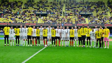 Teams line up with shirts in remembrance of flooding victims in the Valencia region before the Spanish league football match between Villarreal CF and Deportivo Alaves at La Ceramica stadium in Vila-real on November 9, 2024. (Photo by JOSE JORDAN / AFP)