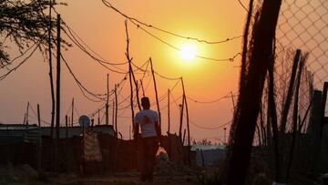 A man walks beneath electrical cables, as coronavirus disease (COVID-19) lockdown regulations ease at the Elias Motsoaledi Informal Settlement in Soweto, South Africa, September 17, 2020. REUTERS/Siphiwe Sibeko