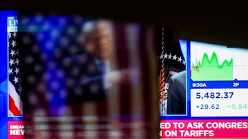 Una bandera cuelga frente a una pantalla que muestra al presidente de Estados Unidos, Donald Trump, durante una rueda de prensa en la Casa Blanca tras la decisión del Tribunal Supremo sobre los aranceles, en la Bolsa de Nueva York (NYSE), en la ciudad de Nueva York, Estados Unidos, el 20 de febrero de 2026.
