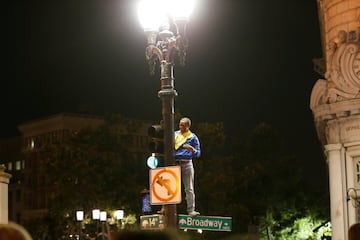 Un aficionado subido a una farola.