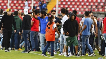 Momento en que varios aficionados ingresan a la cancha del Corriegidora