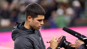 INDIAN WELLS, CALIFORNIA - MARCH 13: Carlos Alcaraz of Spain signs on the camera lens with (Should I buy a house here?) after his straight set victory against Francisco Cerundolo of Argentina in their Quarterfinal round match during the BNP Paribas Open at Indian Wells Tennis Garden on March 13, 2025 in Indian Wells, California. Clive Brunskill/Getty Images/AFP (Photo by CLIVE BRUNSKILL / GETTY IMAGES NORTH AMERICA / Getty Images via AFP)