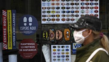 A graphic design store displays a catalogue of customized face masks and different signs to keep social distancing for sale in Buenos Aires, on May 13, 2020, amid the new coronavirus pandemic. (Photo by JUAN MABROMATA / AFP)
