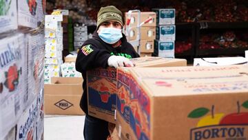 Un trabajador de una tienda de comestibles desempaca cajas de comida afuera de una tienda de comestibles de Brooklyn el 23 de abril de 2020.