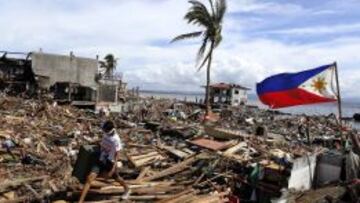 Un hombre camina entre los escombros tras el paso del devastador tif&oacute;n &quot;Haiyan&quot; en Tacloban (Filipinas).