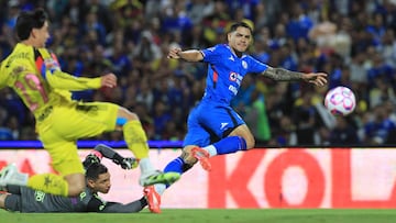 Cruz Azul's Uruguayan forward #21 Gabriel Fernandez scores past America's goalkeeper #01 Luis Malagon and defender #29 Ramon Juarez during the Liga MX Apertura football tournament match between Cruz Azul and america at the Olimpico Universitario Stadium in Mexico City on October 18, 2025. (Photo by Victor Cruz / AFP)
