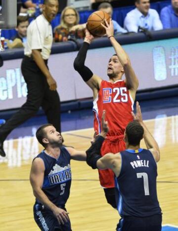 El jugador Austin Rivers de Los Angeles Clippers lanza ante la marca de José Juan Barea y Dwight Powell de Dallas Mavericks.