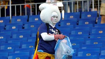 Aficionados japoneses limpian la grada tras el partido Bélgica-Japón