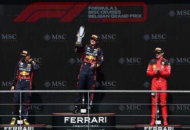 Max Verstappen levanta el trofeo como campeón del GP de Bélgica 2023, franqueado en el podio por Sergio Pérez y Charles Leclerc.