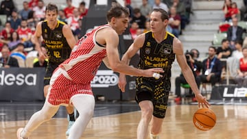 El base de La Laguna Tenerife Marcelinho Huertas (d) bota el balón ante el escolta de UCAM Murcia Wilhelm Falk (i) durante el partido de la vigésima octava jornada de la Liga Endesa celebrado este sábado en el Palacio de los Deportes de Murcia.