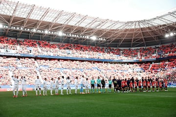 Los jugadores del Osasuna y del Real Madrid saludan en el centro del campo. 