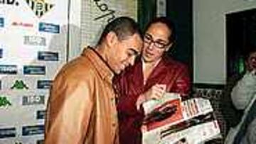 Denilson mira la revista donde aparece con Vicky Martín Berrocal.