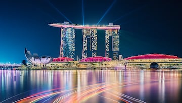 Singapore - October 24, 2019: Singapore skyline taken at night with the famous hotel Marina Bay Sands, the reflections of the buildings and the light trails of the boats painted in the bay water