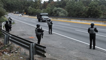 Members of the National Guard man a checkpoint on the highway connecting Mexico City with the state of Puebla, following roadblocks and arson attacks carried out by members of organized crime in several states after a military operation in which a government source said Mexican drug lord Nemesio Oseguera, known as “El Mencho,” was killed in Jalisco state, in Santa Rita Tlahuapan, Mexico, February 22, 2026. REUTERS/Paola Garcia