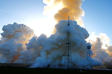 El humo envuelve una torre de protección contra rayos tras el lanzamiento de la misión Artemis II de la NASA para sobrevolar la Luna.