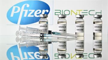 (FILES) This file illustration taken on November 17, 2020 in London shows vials with Covid-19 vaccine stickers attached and syringes with the logo of US pharmaceutical company Pfizer and German partner BioNTech. - Data from 38,000 trial participants invol
