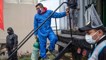 A worker climbs on a truck to recharge an oxygen cylinder for a COVID-19 patient taken by relatives, in Villa Maria del Triunfo, in the southern outskirts of Lima, on July 29, 2020. (Photo by Ernesto BENAVIDES / AFP)