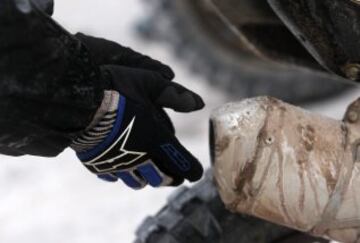 8ª Etapa: Uyuni e Iquique. Un piloto se calienta las manos previo al inicio, el frío el gran protagonista de la jornada.