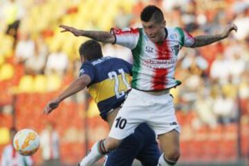 El jugador de Boca Juniors Cristian Erbes, izquierda disputa el balon con Jason Silva de Palestino durante el partido del grupo 5 de la Copa Libertadores en el estadio Santa Laura de Santiago, Chile.