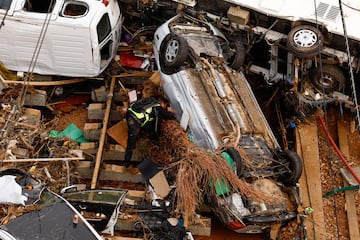 Un miembro de la Guardia Civil Española busca a las víctimas en un coche tras las fuertes lluvias en Alfafar, en Valencia.