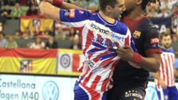 El lateral macedonio del Atlético de Madrid Kiril Lazarov intenta lanzar a puerta ante el pivote del Barcelona Cedric Sorhaindo.