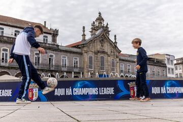 Dos niños juegan con un balón junto a la fuente de la Plaza de la República de Braga.