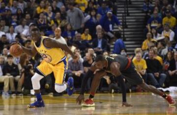 Draymond Green lucha por el balón con Paul Millsap.