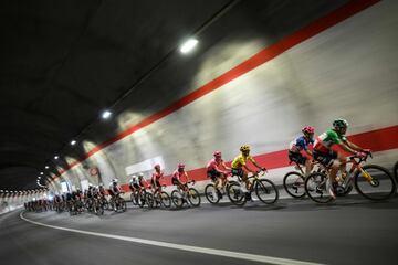 El ciclista ecuatoriano del equipo EasyPost, Richard Carapaz, vistiendo el maillot amarillo de líder general, pedalea con el pelotón de corredores en el túnel de Montgenèvre que une Italia y Francia. 
