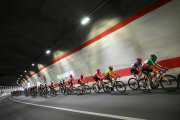 El ciclista ecuatoriano del equipo EasyPost, Richard Carapaz, vistiendo el maillot amarillo de líder general, pedalea con el pelotón de corredores en el túnel de Montgenèvre que une Italia y Francia.