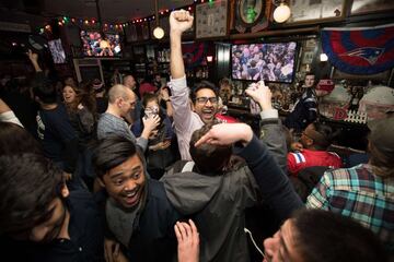 Los aficionados de los Patriots se reunieron en bares para ver el partido mientras comían alitas y bebían cervezas. En la imagen seguidores celebran el final del partido.