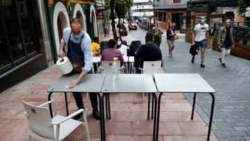 GRAF9617. OVIEDO, 22/05/2020.- Un camarero prepara una mesa en una terraza de la calle Gascona de Oviedo, este viernes. El Principado de Asturias pasar&aacute; a la fase 2 de la desescalada a partir del pr&oacute;ximo lunes, 25 de mayo, ha anunciado el mi