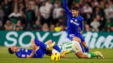 El centrocampista del Betis 'Isco' Alarcón (c) cae ante Yellu Santiago (i) y Diego Rico, ambos del Getafe, durante el partido de LaLiga de fútbol entre Real Betis y Getafe CF.