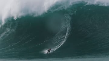 La surfista brasileña Maya Gabeira surfeando una ola gigante de izquierdas, en el bottom de la ola, en Nazaré, con chaleco hinchable rojo. El 5 de febrero del 2021 en Praia do Norte (Nazaré, Portugal).