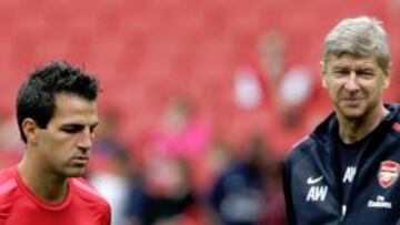 <b>SEGUIRÁ EN EL EMIRATES. </b>Cesc pasa frente a Wenger, en su primer entrenamiento tras las vacaciones.