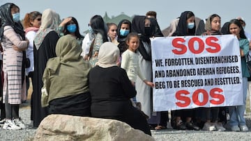 Afghan refugees, who fled Afghanistan in 1996, hold a poster as they attend a rally in front of the US Embassy in Bishkek, on August 19, 2021.