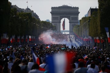 Supporters gather on the Champs-Elysees avenue near the Arch of Triumph (Arc de Triomphe) in Paris on July 16, 2018 as they wait for the arrival of the French national football team for celebrations after France won the Russia 2018 World Cup final footbal
