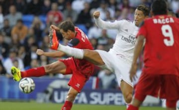 El jugador del Real Madrid, el portugués Cristiano Ronaldo y el defensa Sevillano Fernando Navarro disputan un balón durante la final de la supercopa disputado esta noche en el Cardiff City Stadium de Cardiff (Gales)