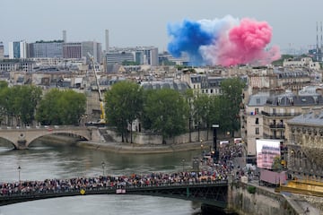 Vista general de la ciudad de París con una espectacular explosión de  humo de colores que forma la bandera de Francia.