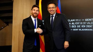 Messi shakes hands with Barcelona president Josep Maria Bartomeu after signing his new contract.