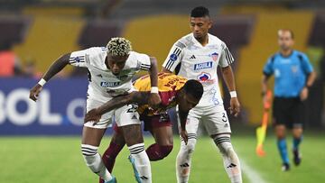 Junior's defender Omar Albornoz (L) and Tolima's midfielder Estefano Arango (C) vie for the ball during the Copa Sudamericana first stage football match between Colombia's Deportes Tolima and Colombia's Junior, at the Manuel Murillo Toro stadium, in Ibague, Colombia, on March 9, 2023. (Photo by Raul ARBOLEDA / AFP)