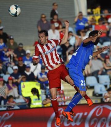 Defensa uruguayo del Atlético de Madrid Diego Godin cabecea el balón para anotar junto centrocampista del Getafe Juan Antonio Rodríguez durante el partido de fútbol de la liga española de Getafe vs Atlético de Madrid en el Coliseum Alfonso Pérez