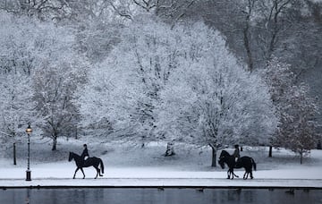 Un par de personas a caballo disfrutan del paisaje de cuento en Hyde Park. 