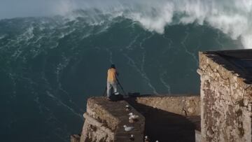 Un se&ntilde;or graba desde el fuerte de San Miguel Arc&aacute;ngel c&oacute;mo rompe una ola en el pico Big Mama de Praia do Norte (Nazar&eacute;, Portugal), en octubre del 2020.