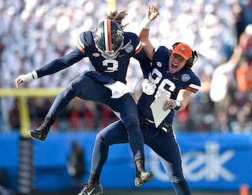 CHARLOTTE, NORTH CAROLINA - DECEMBER 29: Bryce Perkins #3 celebrates with Lindell Stone #36 of the Virginia Cavaliers after throwing a fourth quarter touchdown against the South Carolina Gamecocks during the Belk Bowl at Bank of America Stadium on December 29, 2018 in Charlotte, North Carolina. Virginia won 28-0.
