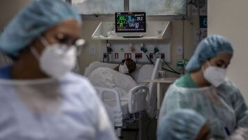 A COVID-19 patient and health workers are seen at an Intensive Care Unit (ICU) of the Ronaldo Gazolla Public Municipal Hospital in Rio de Janeiro, Brazil, on March 5, 2021, a year after the first coronavirus case was registered in the city. (Photo by ANDRE COELHO / AFP)
