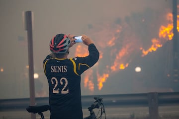 Un hombre toma fotografas mientras el incendio de Palisades arde durante una tormenta de viento en el lado oeste de Los ?ngeles.