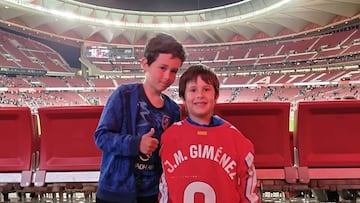 El pequeño Lucas con su hermano Martín, y la camiseta de Giménez, al término del Atlético-Real Sociedad.
