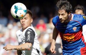 El defensa del Elche Sergio Pelegrín (d) y el delantero chileno del Valencia Eduardo Vargas, en el partido de la trigésima tercera jornada de liga en Primera División que se disputa esta tarde en el estadio de Mestalla.
