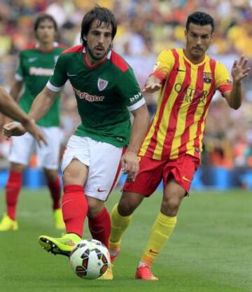 Pedro (d), del FC Barcelona, intenta avanzar con el balón ante la presencia de Beñat (i), del Athletic de Bilbao, durante el partido de Liga jugado esta tarde en el Camp Nou de Barcelona.